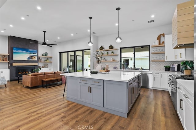 11221 Davenport Rd, Rossmoor, CA 90720 - kitchen with open shelves, appliances with stainless steel finishes, custom range hood, a ceiling fan, and recessed lighting