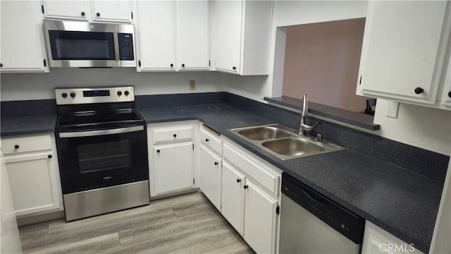 517 Wayland Ct, Claremont, CA 91711 - kitchen featuring appliances with stainless steel finishes, white cabinetry, light wood finished floors, and dark countertops