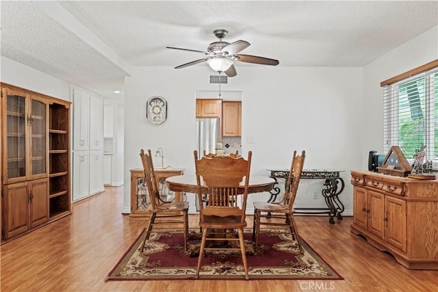 19439 Oak Crossing Rd, Newhall, CA 91321 - dining space featuring light wood-style flooring, a textured ceiling, and ceiling fan