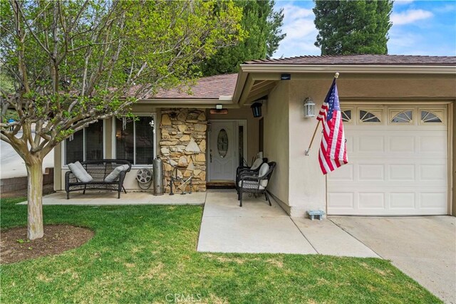 19439 Oak Crossing Rd, Newhall, CA 91321 - doorway to property with a garage, stucco siding, a lawn, concrete driveway, and stone siding
