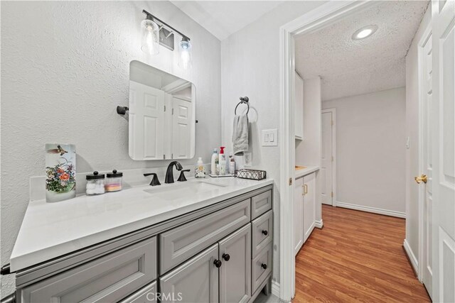 19439 Oak Crossing Rd, Newhall, CA 91321 - bathroom with vanity, a textured ceiling, and wood finished floors