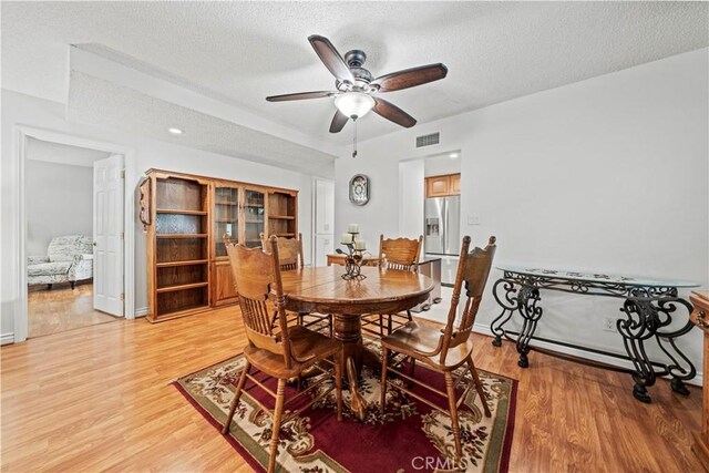 19439 Oak Crossing Rd, Newhall, CA 91321 - dining space featuring a textured ceiling, light wood-style floors, and a ceiling fan