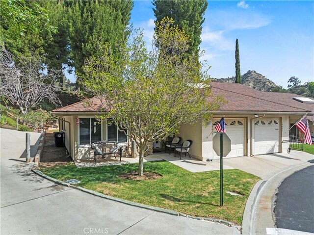 19439 Oak Crossing Rd, Newhall, CA 91321 - view of front of home featuring stucco siding, a garage, driveway, and a front yard