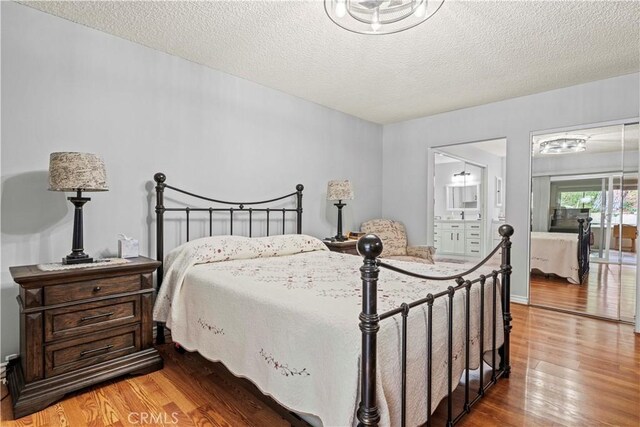 19439 Oak Crossing Rd, Newhall, CA 91321 - bedroom with wood finished floors, a textured ceiling, and ensuite bath