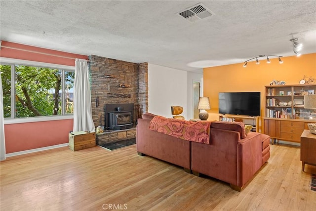 297 Connors Ave, Chico, CA 95926 - living area featuring a textured ceiling, a wood stove, wood-type flooring, and track lighting