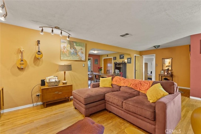297 Connors Ave, Chico, CA 95926 - living room with wood finished floors, baseboards, a textured ceiling, and rail lighting