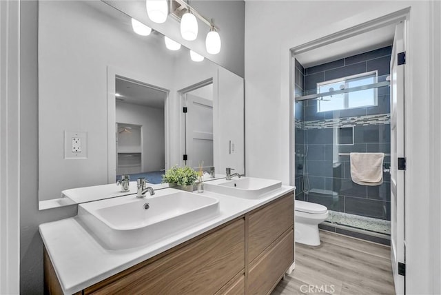 689 Castlehill Dr, Walnut, CA 91789 - bathroom featuring toilet, a stall shower, wood finished floors, and double vanity