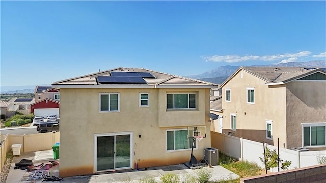 36927 Arezzo Ct, Beaumont, CA 92223 - rear view of property featuring a mountain view, central AC, roof mounted solar panels, stucco siding, and a fenced backyard