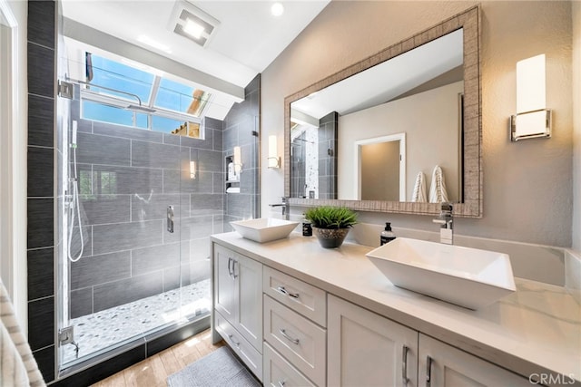 417 Via Presa, San Clemente, CA 92672 - full bathroom featuring vaulted ceiling, a shower stall, double vanity, and wood finished floors