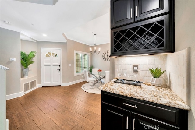 417 Via Presa, San Clemente, CA 92672 - kitchen featuring dark cabinetry, a chandelier, ornamental molding, tasteful backsplash, and recessed lighting