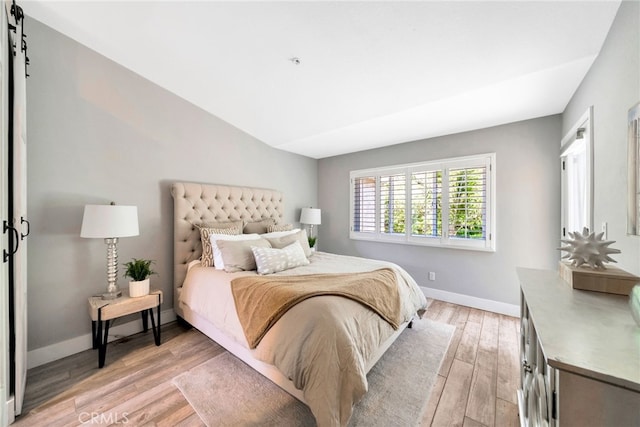 417 Via Presa, San Clemente, CA 92672 - bedroom featuring light wood finished floors, baseboards, vaulted ceiling, and a barn door
