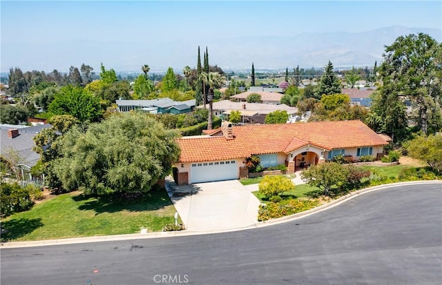 645 Alta Loma Dr, Redlands, CA 92373 - view of front of house featuring driveway, a tiled roof, a front lawn, stucco siding, and a mountain view