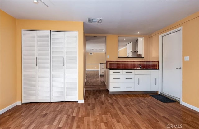 645 Alta Loma Dr, Redlands, CA 92373 - kitchen featuring dark countertops, wood finished floors, white cabinetry, and baseboards
