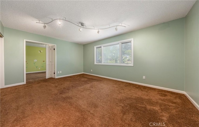 645 Alta Loma Dr, Redlands, CA 92373 - carpeted spare room featuring baseboards, a textured ceiling, and rail lighting