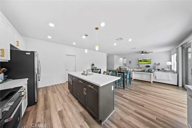 2569 Pasture Gln, Escondido, CA 92029 - kitchen with stainless steel appliances, a kitchen island, light countertops, a ceiling fan, and light wood-style flooring