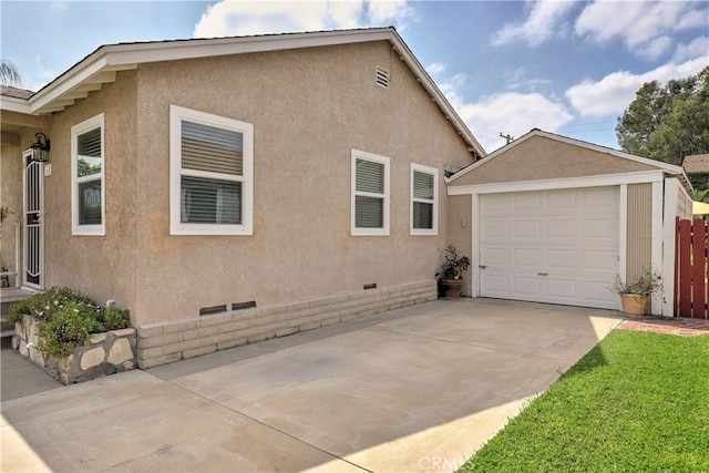view of home's exterior featuring an outdoor structure, stucco siding, concrete driveway, crawl space, and a garage