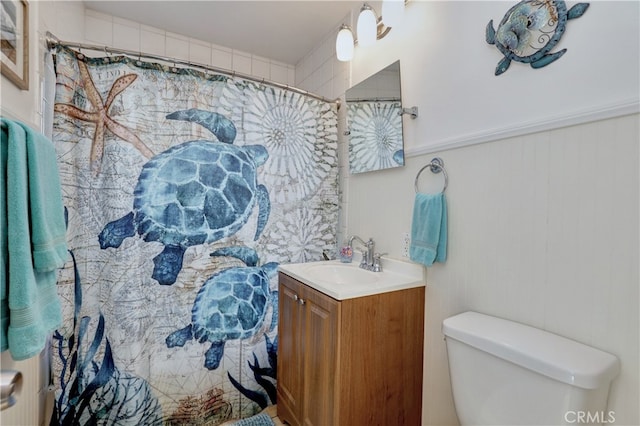 bathroom featuring toilet, vanity, and curtained shower