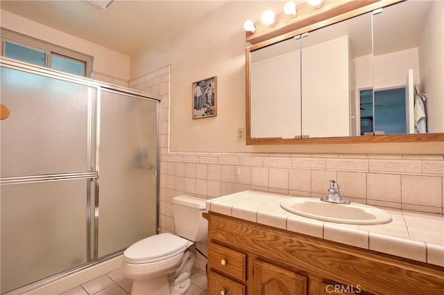 full bathroom featuring tile patterned floors, a shower stall, vanity, tile walls, and toilet