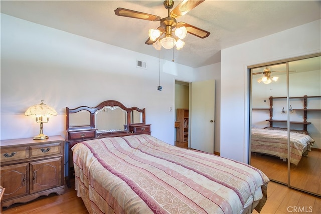 bedroom featuring light wood-style flooring, a closet, and ceiling fan
