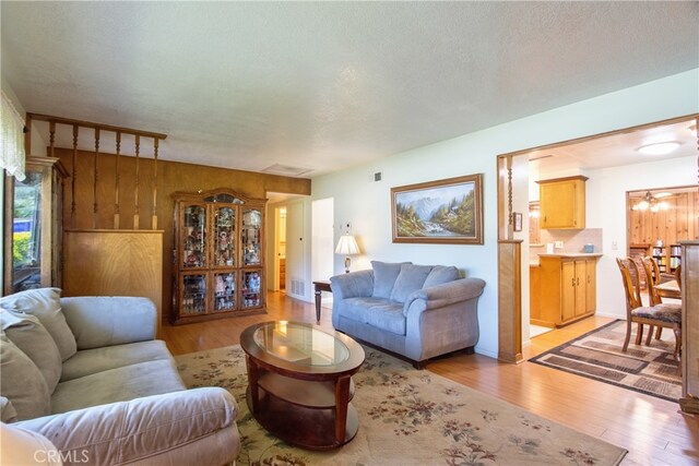 living room with light wood-style floors and a textured ceiling