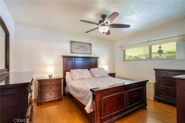 bedroom with light wood-style floors and a ceiling fan
