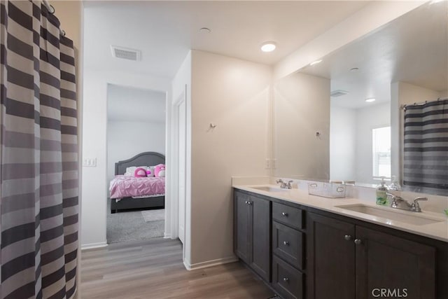 959 Rockcress Ln, Banning, CA 92220 - full bathroom featuring wood finished floors, double vanity, baseboards, a shower with curtain, and ensuite bathroom