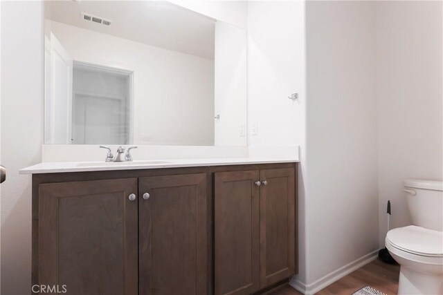959 Rockcress Ln, Banning, CA 92220 - bathroom featuring toilet, wood finished floors, vanity, and baseboards