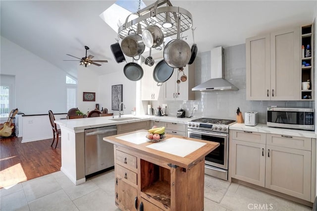 25552 Paseo La Vis Unit 20, Laguna Niguel, CA 92677 - kitchen with wall chimney exhaust hood, appliances with stainless steel finishes, open shelves, a sink, and a peninsula