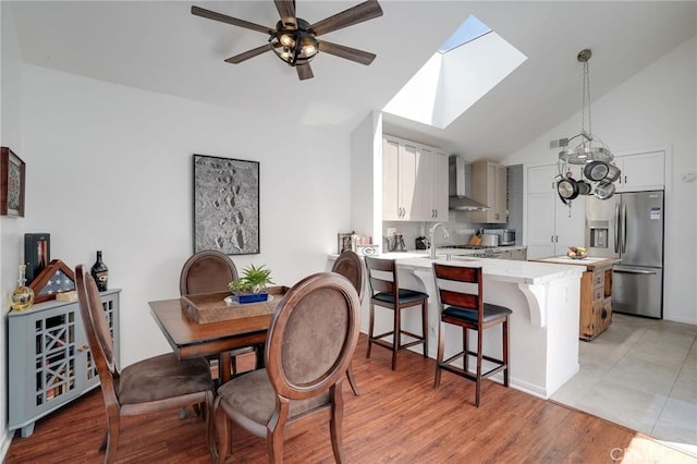 25552 Paseo La Vis Unit 20, Laguna Niguel, CA 92677 - dining area with a skylight, ceiling fan, light wood finished floors, and high vaulted ceiling