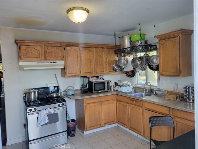 2112 E Lucien St, Compton, CA 90222 - kitchen with stainless steel appliances, a sink, under cabinet range hood, light tile patterned floors, and brown cabinetry