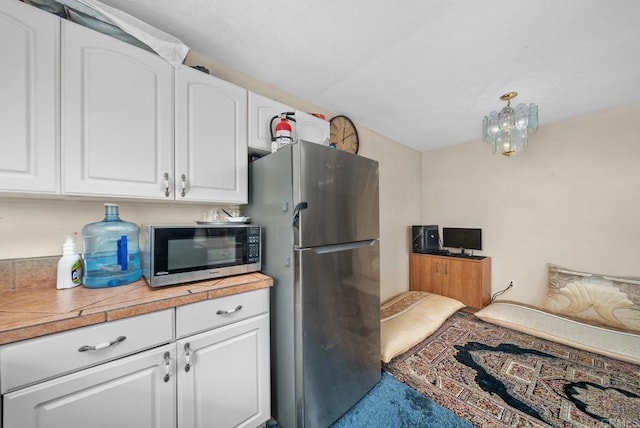 908 S Sunshine Ave Unit 18, El Cajon, CA 92020 - kitchen featuring appliances with stainless steel finishes, white cabinetry, light countertops, and carpet