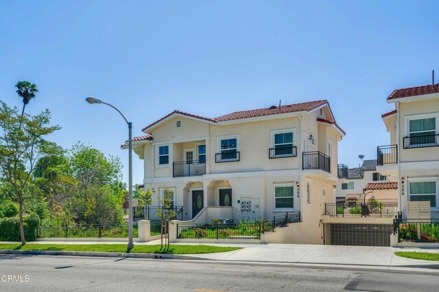 300 E Alhambra Rd Unit D, Alhambra, CA 91801 - view of front facade featuring a fenced front yard, stucco siding, a tile roof, a balcony, and a gate