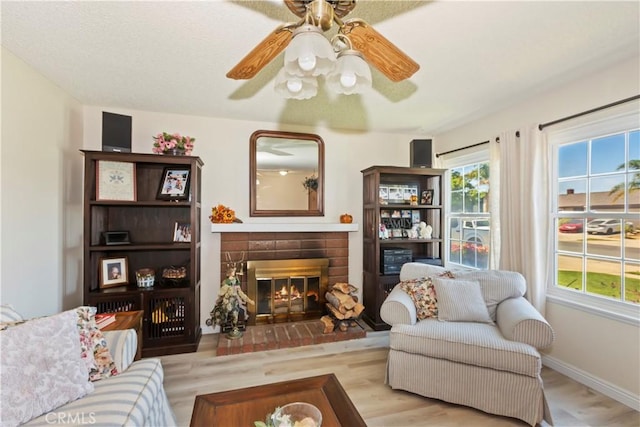 7030 Idyllwild Ln, Riverside, CA 92503 - living room featuring ceiling fan, wood finished floors, a fireplace, and baseboards