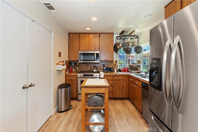 7030 Idyllwild Ln, Riverside, CA 92503 - kitchen featuring stainless steel appliances, backsplash, brown cabinets, a center island, and recessed lighting