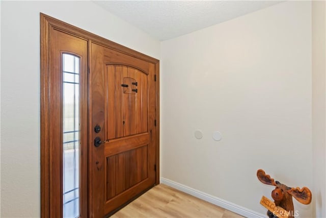 7030 Idyllwild Ln, Riverside, CA 92503 - foyer with baseboards, light wood-style floors, and a textured ceiling