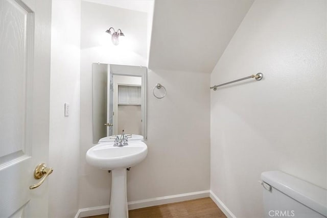 2923 Cottage Ln, Paso Robles, CA 93446 - half bathroom featuring toilet, lofted ceiling, baseboards, wood finished floors, and a sink