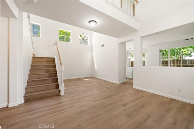 2923 Cottage Ln, Paso Robles, CA 93446 - unfurnished living room featuring a chandelier, light wood-type flooring, stairs, and baseboards