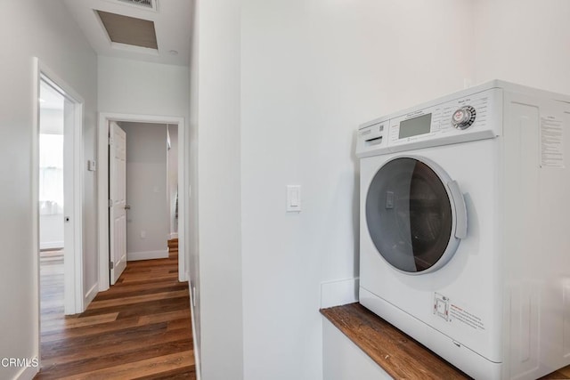 laundry area with washer / dryer, dark wood-style flooring, and baseboards