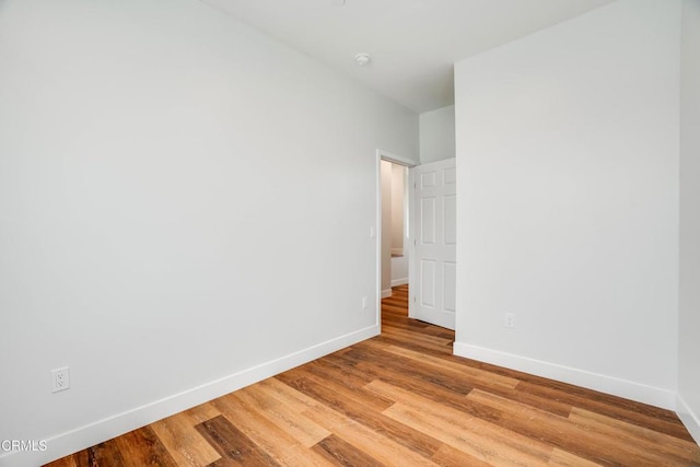 unfurnished room featuring baseboards and light wood-type flooring