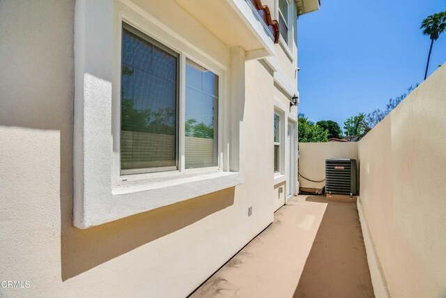 view of side of property featuring stucco siding and central AC unit