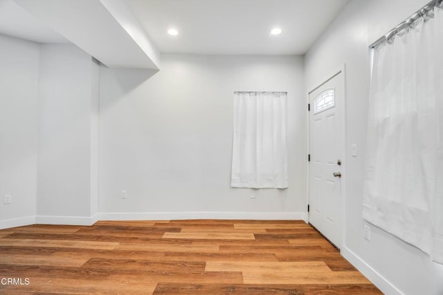 foyer entrance with wood finished floors, baseboards, and recessed lighting
