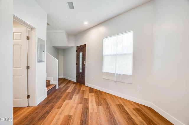 entrance foyer featuring stairs, wood finished floors, baseboards, recessed lighting, and electric panel