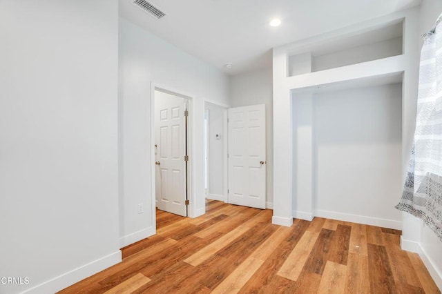 hall featuring light wood-style floors, recessed lighting, and baseboards