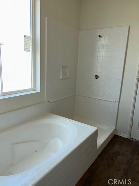 full bath with wood finished floors, a garden tub, and a shower