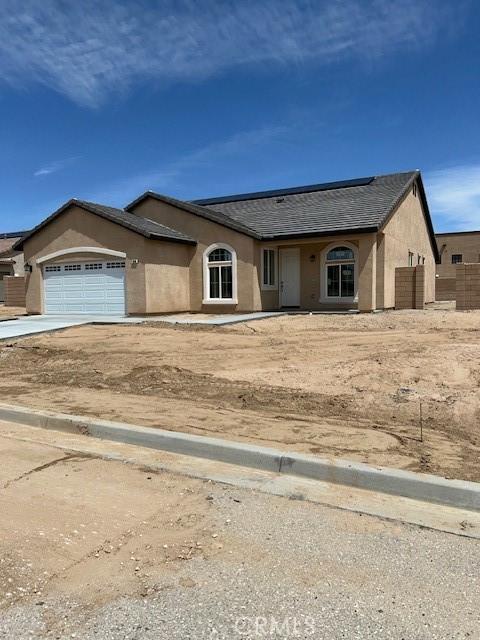 view of front of home featuring an attached garage, driveway, and stucco siding