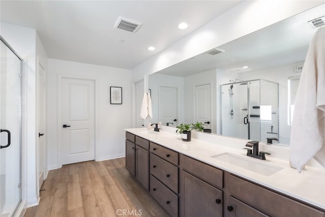 25367 Circle Stone Dr, Menifee, CA 92586 - bathroom with wood finished floors, a shower stall, double vanity, recessed lighting, and baseboards