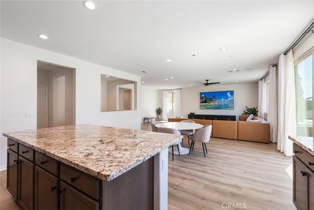 25367 Circle Stone Dr, Menifee, CA 92586 - kitchen featuring light wood-type flooring, recessed lighting, dark brown cabinets, ceiling fan, and light stone counters
