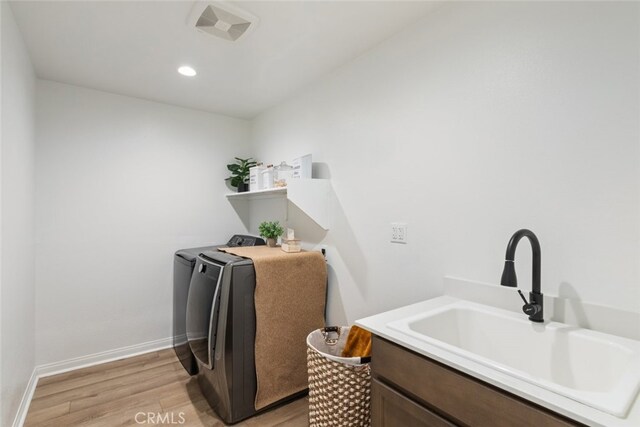 25367 Circle Stone Dr, Menifee, CA 92586 - washroom featuring washer and clothes dryer, light wood finished floors, and baseboards