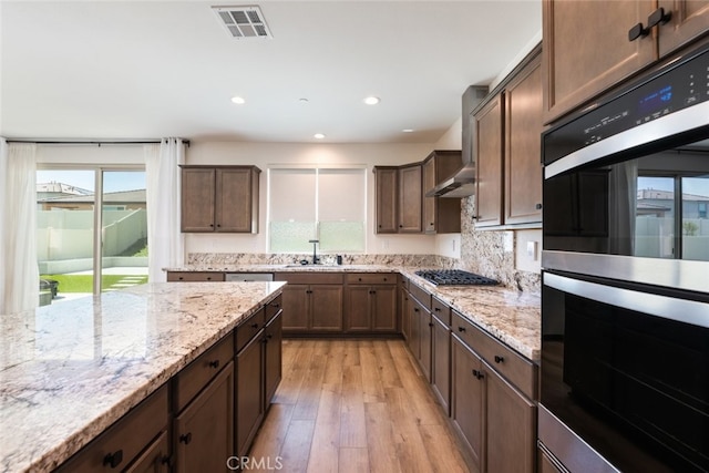 25367 Circle Stone Dr, Menifee, CA 92586 - kitchen with double oven, healthy amount of natural light, light wood-style flooring, light stone countertops, and recessed lighting