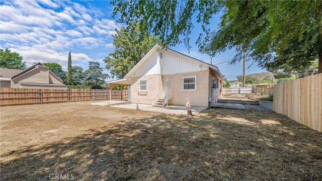 back of property with a patio, entry steps, a fenced backyard, and stucco siding